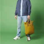 SAC A DOS – 2 Homme portant un Sac a dos jaune a la main